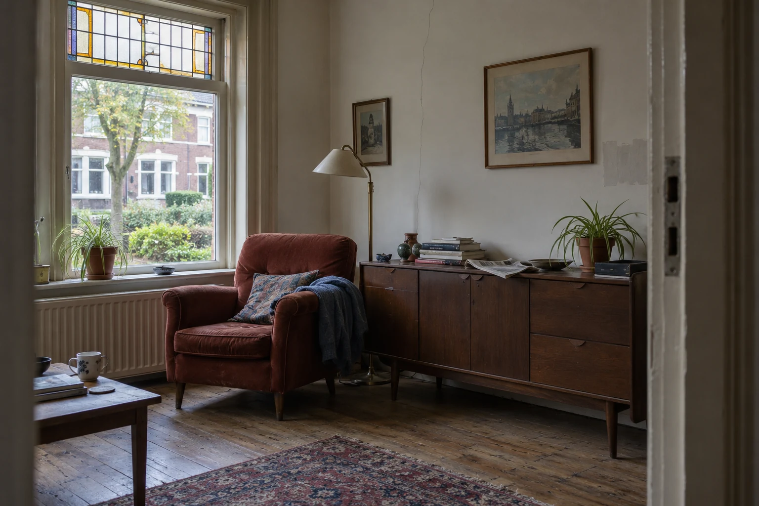 Sfeerbeeld van een bewoonde jaren-30-woonkamer met ouder hout en glas-in-lood